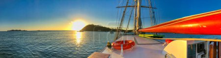 Téléchargez les photos : Naviguer le long de magnifiques îles scénario. Vue panoramique sur le coucher du soleil depuis le voilier. - en image libre de droit