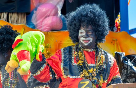 Photo for New Orleans, LA - February 9, 2016: Masked people along Mardi Gras Parade in Bourbon Street. Mardi Gras is the biggest celebration the city of New Orleans hosts every year. - Royalty Free Image