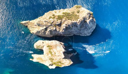 Téléchargez les photos : Vue aérienne imprenable sur les rochers Faraglioni au-dessus de la mer dans l'île de Capri, en Italie. Point de vue du drone. - en image libre de droit
