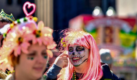Foto de New Orleans, LA - February 9, 2016: Masked people along Mardi Gras Parade in Bourbon Street. Mardi Gras is the biggest celebration the city of New Orleans hosts every year. - Imagen libre de derechos