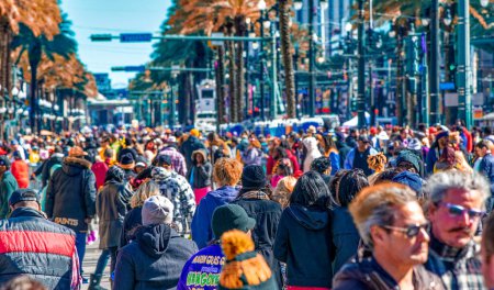Foto de New Orleans, LA - February 9, 2016: Tourists and locals along Mardi Gras Parade in Bourbon Street. Mardi Gras is the biggest celebration the city of New Orleans hosts every year. - Imagen libre de derechos