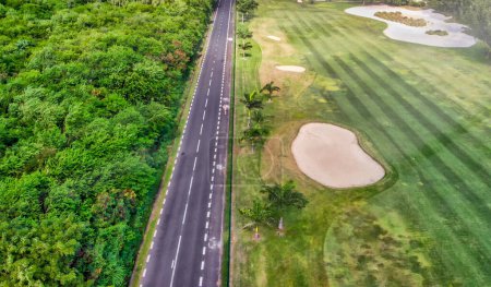 Téléchargez les photos : Terrain de golf le long d'une belle côte insulaire, point de vue de drone. - en image libre de droit