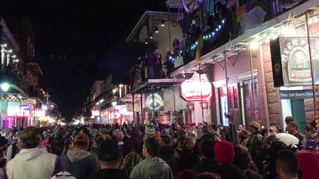 Téléchargez les photos : New Orleans, LA - February 9, 2016: Crowd of tourists and locals along the city streets at night for Mardi Gras event. - en image libre de droit