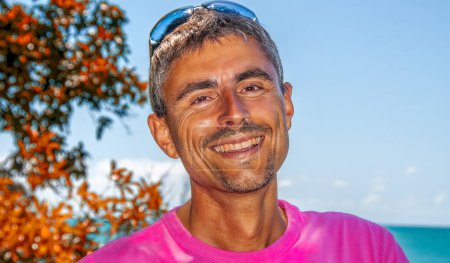 Téléchargez les photos : Portrait d'un homme caucasien heureux se relaxant sur une belle plage tropicale. - en image libre de droit