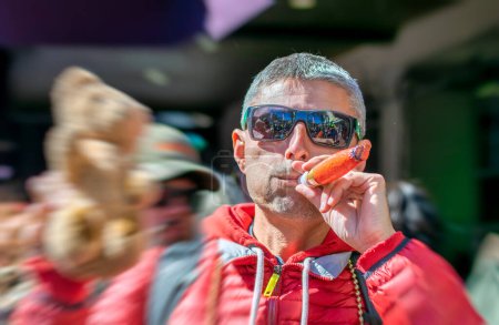 Téléchargez les photos : Un homme heureux au carnaval de la Nouvelle-Orléans sur Mardi gras fait semblant de fumer un cigare jouet. - en image libre de droit