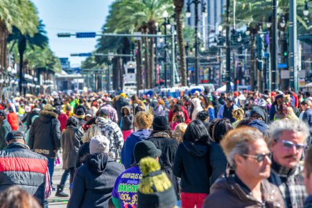 Foto de New Orleans, LA - February 9, 2016: Tourists and locals along Mardi Gras Parade in Bourbon Street. Mardi Gras is the biggest celebration the city of New Orleans hosts every year. - Imagen libre de derechos