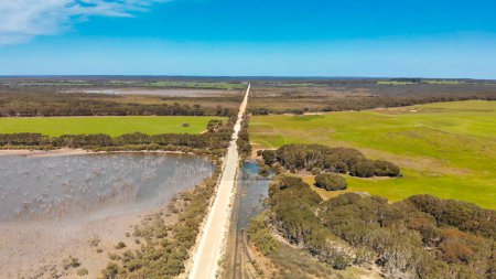 Téléchargez les photos : Kangaroo Island unpaved road along lake and trees, aerial view from drone - Australia. - en image libre de droit