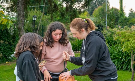 Téléchargez les photos : Jeunes filles coupant Halloween Citrouille. - en image libre de droit