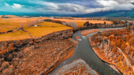 Photo for Overhead aerial view of a river across a valley - Drone viewpoint. - Royalty Free Image
