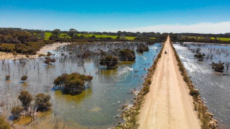 Foto de Kangaroo Island unpaved road along lake and trees, aerial view from drone - Australia. - Imagen libre de derechos