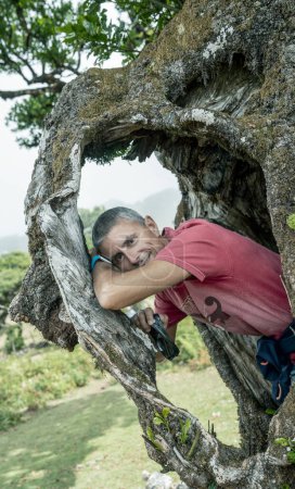 Téléchargez les photos : Portrait d'homme encadré à l'intérieur des racines d'un tronc d'arbre. - en image libre de droit