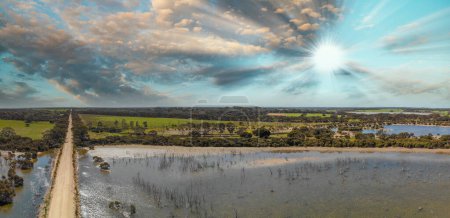 Téléchargez les photos : Vue aérienne panoramique de la route, du lac et des arbres de l'île Kangourou au coucher du soleil, Australie-Méridionale. - en image libre de droit
