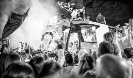 Téléchargez les photos : PISA, ITALY - JUNE 15TH, 2016: Local fans celebrate the soccer team's promotion. Celebrations in the night with smoke bombs and an open bus. - en image libre de droit