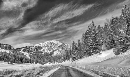 Foto de Road through a beautiful snowy valley, dolomite mountains in winter season. - Imagen libre de derechos