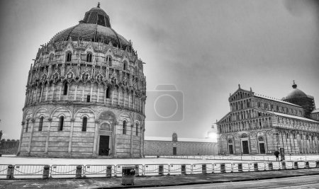 Foto de Pisa bajo la nieve. Monumentos y monumentos famosos del Campo de los Milagros después de una tormenta de nieve. - Imagen libre de derechos