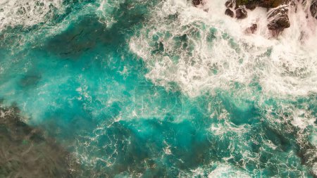 Foto de Turbulent waters near a rocky shoreline, amazing aerial view from drone. - Imagen libre de derechos