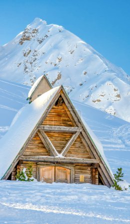Téléchargez les photos : Wooden Hut in the middle of a valley covered by snow in winter season. - en image libre de droit
