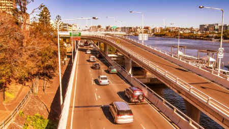 Téléchargez les photos : Trafic urbain le long de la rivière Brisbane sur une route principale de la ville, Australie - en image libre de droit