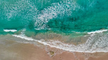 Foto de Above the ocean, aerial view at the waves and surface near shoreline - Drone viewpoint. - Imagen libre de derechos