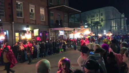 Téléchargez les photos : New Orleans, LA - February 9, 2016: Crowd of tourists and locals along the city streets at night for Mardi Gras event. - en image libre de droit