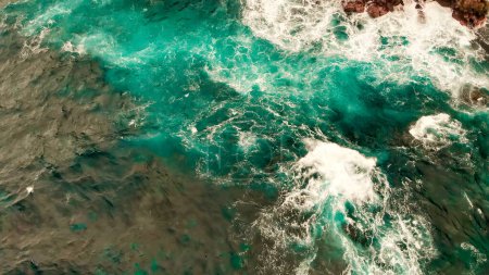 Foto de Turbulent waters near a rocky shoreline, amazing aerial view from drone. - Imagen libre de derechos