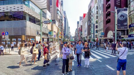 Foto de TOKIO - 22 DE MAYO DE 2016: Turistas en Ginza. Tokio atrae a 5 millones de visitantes extranjeros cada año
. - Imagen libre de derechos