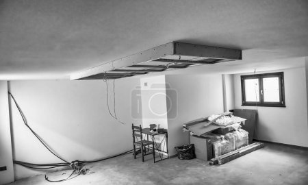 Foto de Acabado de obras en una casa nueva. Techos suspendidos. Preparación de techo de paneles de yeso para luz led - Imagen libre de derechos