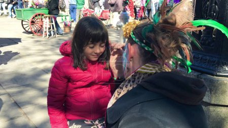 Téléchargez les photos : Little girl gets her face painted at New Orleans Carnival. - en image libre de droit