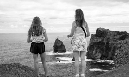 Téléchargez les photos : Femme et sa fille regardant les rochers au-dessus de la mer depuis Miradouro de Sao Lourenco dans l'île de Madère, Portugal. - en image libre de droit