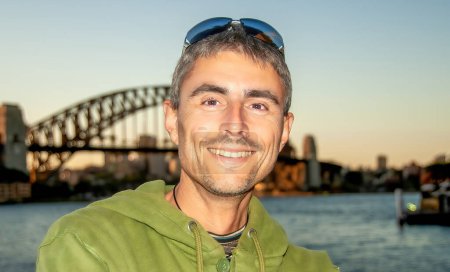 Téléchargez les photos : Portrait d'un homme caucasien heureux visitant le port de Sydney au coucher du soleil. - en image libre de droit