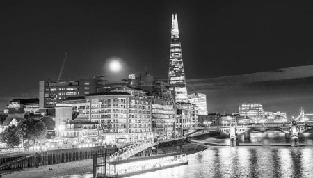 Foto de Skyline nocturno de Londres con reflejos del río Támesis - Imagen libre de derechos