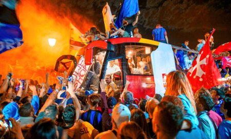 Foto de PISA, ITALIA - 15 DE JUNIO DE 2016: Los aficionados locales celebran la promoción del equipo de fútbol. Celebraciones en la noche con bombas de humo y un autobús abierto. - Imagen libre de derechos