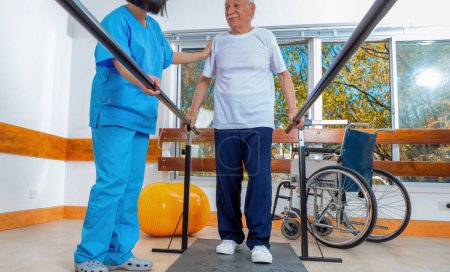 Téléchargez les photos : Infirmière asiatique aidant un aîné avec un marcheur à l'hôpital. Concept de réhabilitation. - en image libre de droit