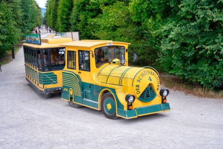 Foto de Viena, Austria - 20 de agosto de 2022: Turistas a lo largo del Parque del Castillo de Schonbrunn montando el tren amarillo. - Imagen libre de derechos