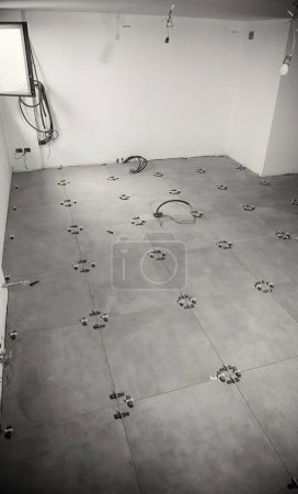 Photo for Laying the tiles on the basement room floor. Moving to a new house concept. - Royalty Free Image