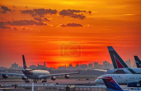 Photo for New York City - April 2009: Airplanes at sunset along the runway at JFK international airport. - Royalty Free Image