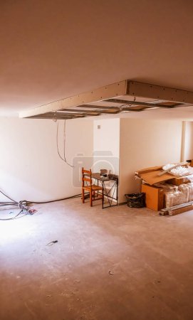 Foto de Acabado de obras en una casa nueva. Techos suspendidos. Preparación de techo de paneles de yeso para luz led - Imagen libre de derechos