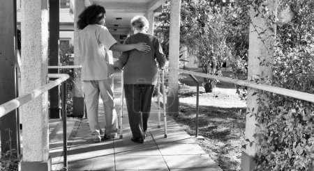 Foto de Doctora africana hablando con anciana jubilada con bastón en el patio del hospital. Concepto de felicidad, rehabilitación y jubilación. - Imagen libre de derechos