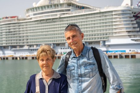 Photo for A ma with his mother in front of a cruise ship in the city port. - Royalty Free Image