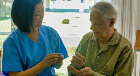 Téléchargez les photos : Jeune asiatique femme médecin aider les personnes âgées retraité prendre la pilule médicale sur le lit d'hôpital. - en image libre de droit
