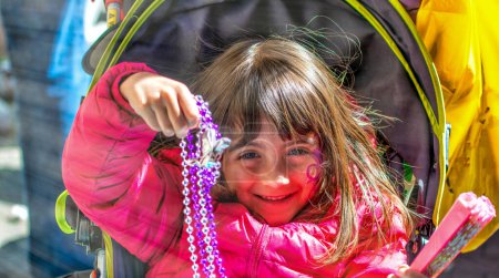 Photo for Happy smiling young girl wearing beads in Mardi Gras Carnival Parade, New Orleans - Royalty Free Image