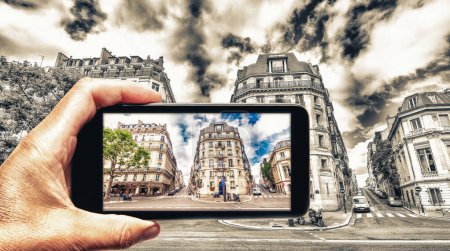 Photo for Taking colors out of black and white. Female hand with smartphone taking a picture of Paris. Tourism concept. - Royalty Free Image