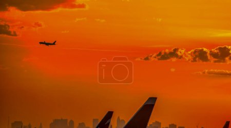 Foto de Backlit view of airplanes on the airport runway at sunset. Travel around the world concept. - Imagen libre de derechos