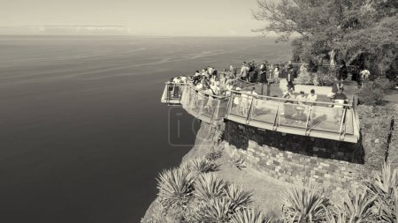 Téléchargez les photos : Tourists enjoy the viewpoint at Cabo Girao, along the Madeira coastline, Portugal. Aerial view from drone. - en image libre de droit