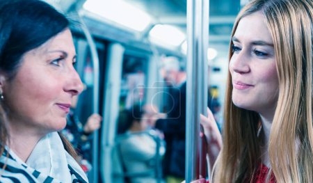 Foto de Un par de amigas felices hablando en un tren subterráneo
. - Imagen libre de derechos