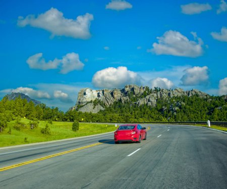 Foto de Coche rojo acelerando en el camino al Monte Rushmore. - Imagen libre de derechos