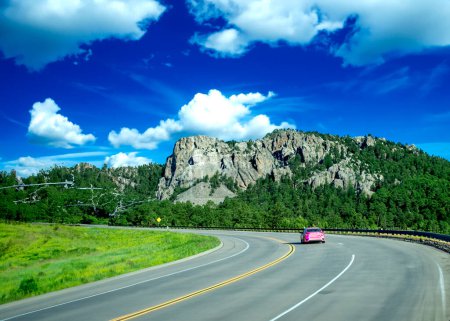 Foto de Coche rojo acelerando en el camino al Monte Rushmore. - Imagen libre de derechos