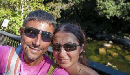 Foto de Selfie de una feliz pareja caucásica de vacaciones relajándose visitando un bosque. - Imagen libre de derechos