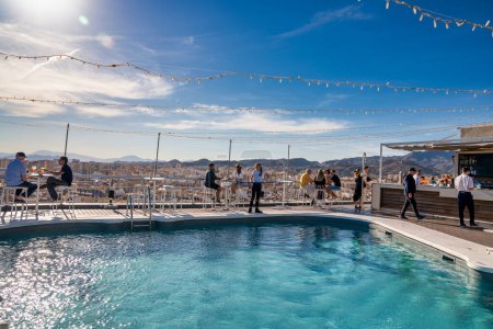 Téléchargez les photos : Malaga, Espagne - 14 avril 2023 : Les gens aiment passer du temps en plein air le long d'une piscine. - en image libre de droit