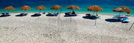 Téléchargez les photos : Vue aérienne d'une rangée de parasols le long d'une belle plage aux eaux cristallines. - en image libre de droit
